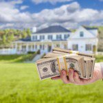 Handing Over Cash For House in Front of Beautiful New Home.